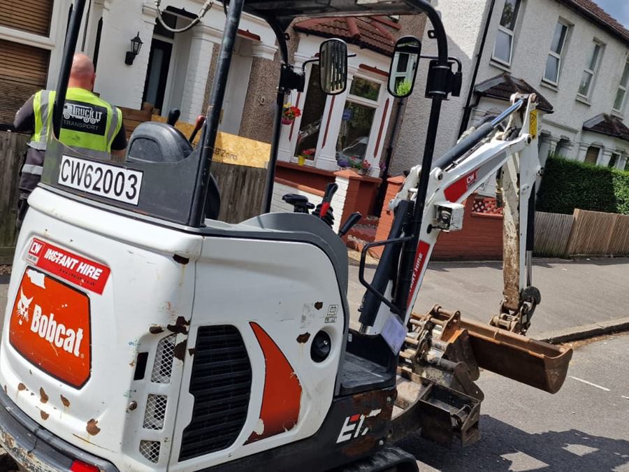 Mini digger arriving on site in a London street